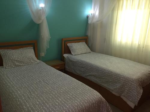 een slaapkamer met 2 bedden en een raam bij Sharks Bay Oasis Apartment in Sharm El Sheikh
