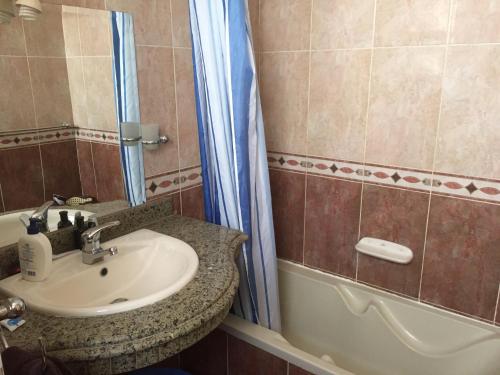 uma casa de banho com um lavatório e uma banheira em Sharks Bay Oasis Apartment em Sharm el Sheikh