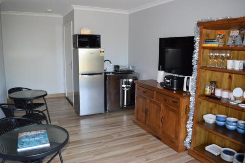 a kitchen with a refrigerator and a table and chairs at Eagle Bay House in Dunsborough