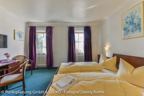 a hotel room with two beds and a table at Das Schwanstein in Schwangau