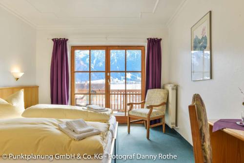 a hotel room with two beds and a window at Das Schwanstein in Schwangau