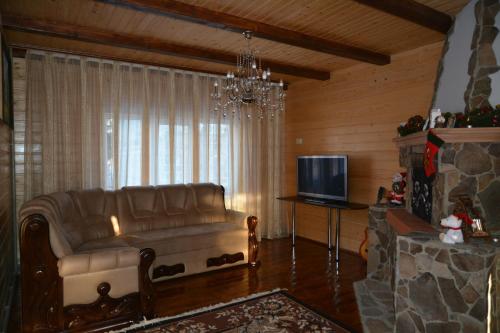 a living room with a couch and a television at Котедж Соняшник in Verkhovyna