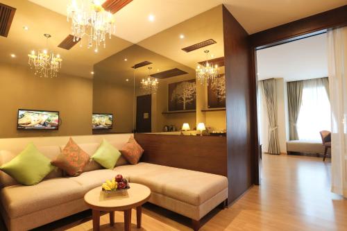 
a living room filled with furniture and a tv at Le Patta Hotel Chiang Rai SHA Extra Plus in Chiang Rai
