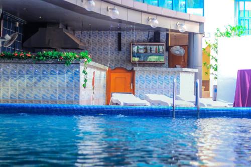 una piscina de agua azul frente a un edificio en Hôtel Prince De Galles, en Douala