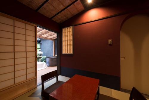 a dining room with a table and a window at Kamishichiken Oku in Kyoto