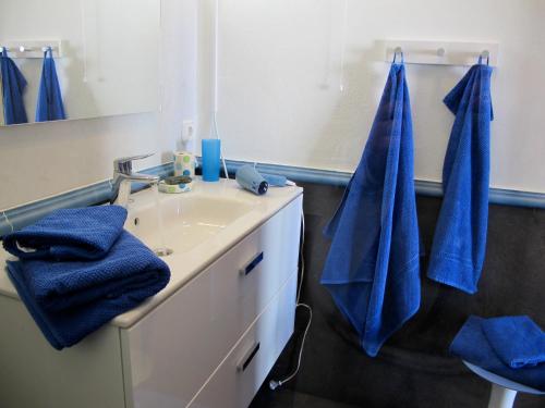 a bathroom with a sink and a mirror and blue towels at VILLA DE LA VISTA in Playa Blanca