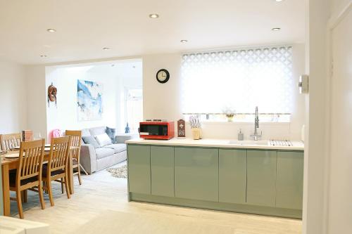 a kitchen and living room with a couch and a table at Lions Den - Zoo Accommodation Chester in Chester