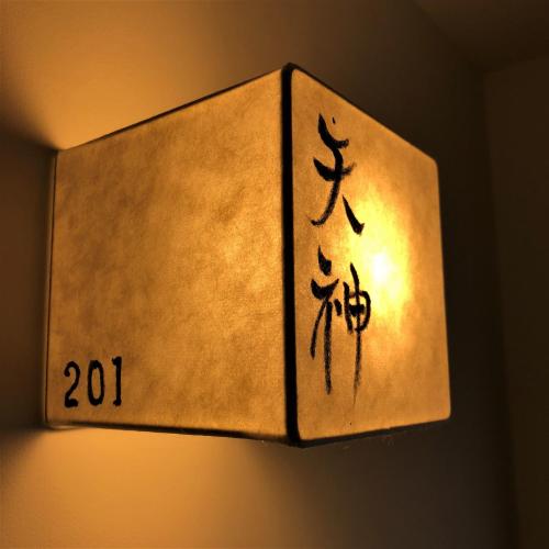 a light with a sign that says on it at Kamishichiken Oku in Kyoto
