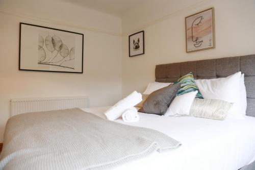a bedroom with a white bed with three pictures on the wall at Lions Den - Zoo Accommodation Chester in Chester