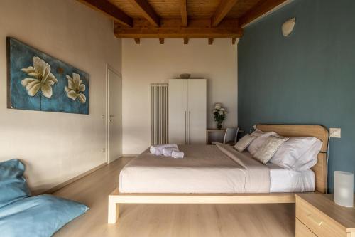 1 dormitorio con 1 cama y una pintura en la pared en Il Giardino Di Lory, en Vercana