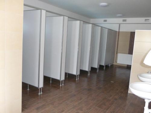 a row of stalls in a bathroom with sinks and toilets at Camping u Kukačků in Horní Planá