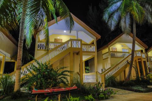 a yellow building with stairs and palm trees at night at LAGUNA BEACH in Morondava