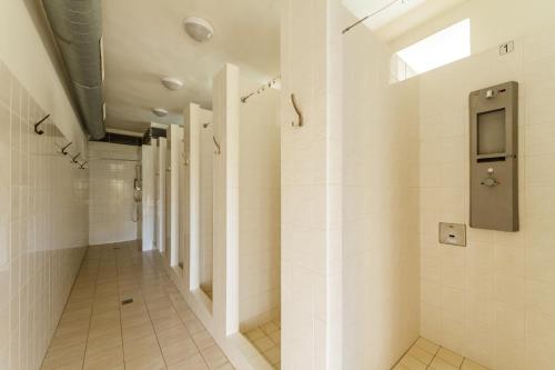 a bathroom with white tile walls and a walk in shower at Camping u Kukačků in Horní Planá