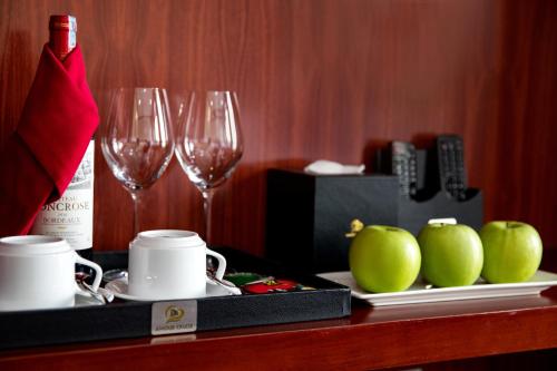 a table with two wine glasses and apples on it at Dora Cruise by HAG in Ha Long