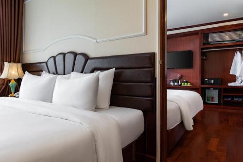 a hotel room with two beds and a television at Dora Cruise by HAG in Ha Long