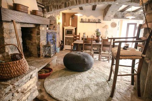 a living room with a fireplace and a table and chairs at Casa Alma Grotto in Brione sopra Minusio