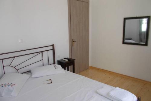 a bedroom with a white bed and a mirror at Square 's House in Lefkada