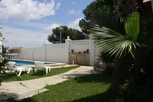 a backyard with a white fence and a pool at Hauzify I Villa Parc in Hospitalet de l'Infant