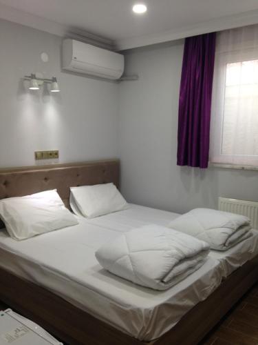 a bed with white sheets and pillows in a bedroom at seasidehouse in Ordu