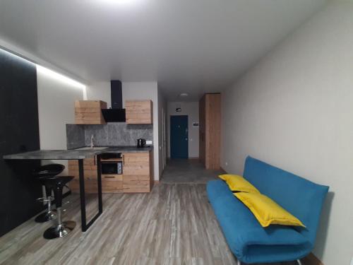 a living room with a blue couch and a table at Solo Apartment Kamenskaya in Kyiv