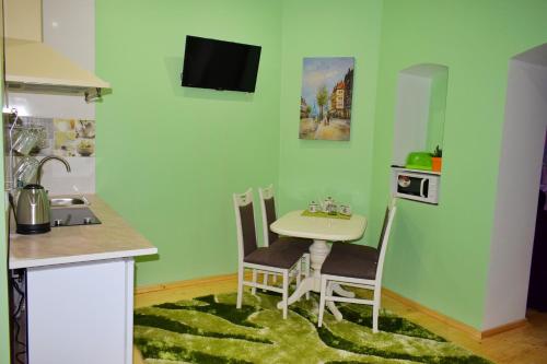 a kitchen with a small table and chairs in a room at Apartments Provence in Chernivtsi