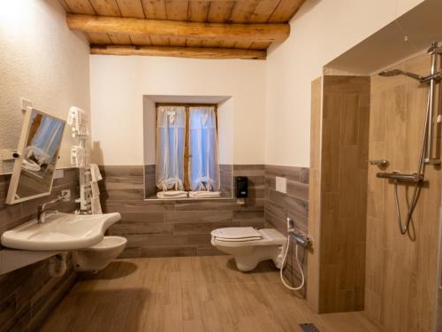 a bathroom with a sink and a toilet and a shower at Locanda Ponte Serra in Lamon