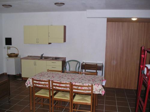 Ollomont的住宿－Dortoir de Ollomont，厨房配有桌子、椅子和桌子,厨房