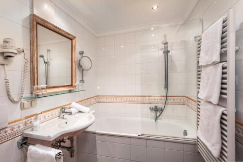 a bathroom with a sink and a bath tub at Appartement Sport Steger in Saalbach-Hinterglemm