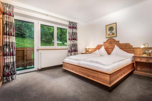a bedroom with a wooden bed and a window at Appartement Sport Steger in Saalbach-Hinterglemm