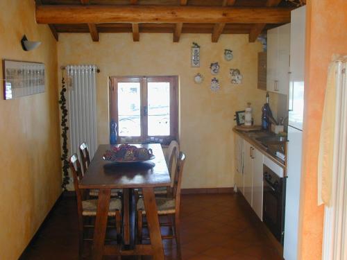 uma cozinha com uma mesa de madeira e cadeiras num quarto em Mansarda Vista lago a Campodolcino em Campodolcino