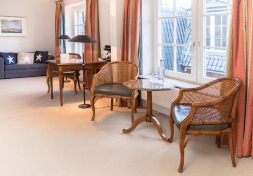 シュトランデにあるStrandhotel Strandeのリビングルーム(テーブル、椅子、窓付)