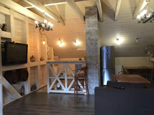 a kitchen with a refrigerator and a table in a room at Вілла Лісова комфорт in Skhidnitsa