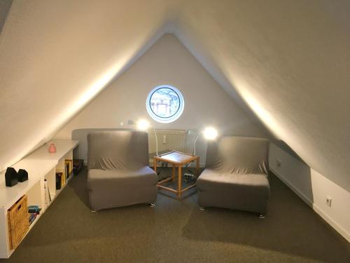 two chairs and a table in a attic with a window at Studio Emilie in Detmold