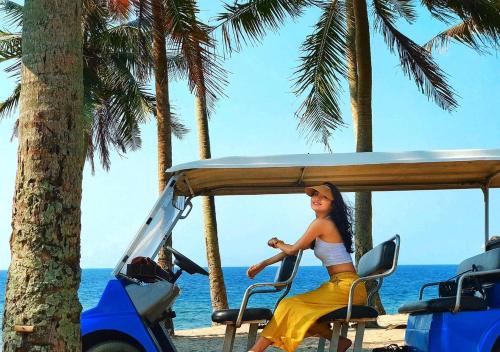 a woman sitting in a golf cart on the beach at Ly Tri Ly Son Hotel in Ly Son