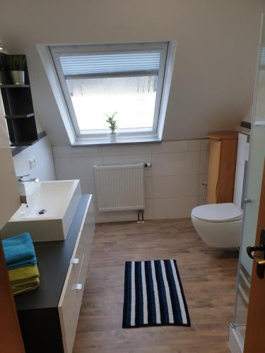 a bathroom with a window and a sink and a toilet at Wohlfühl-Apartment Bad Kissingen IV in Bad Kissingen