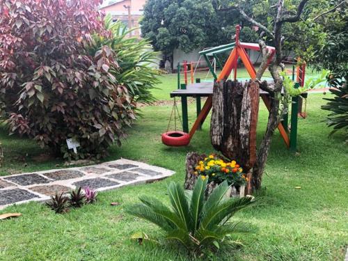 a playground in a yard with a swing at Hotel Santa Amalia in Vassouras