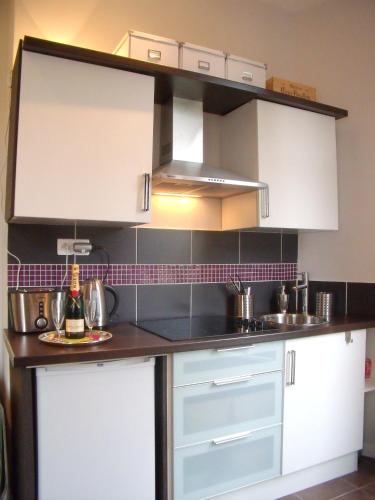 une cuisine avec des armoires blanches et un évier dans l'établissement Nizza - Boutique Wohnung - near Hotel Negresco, à Nice