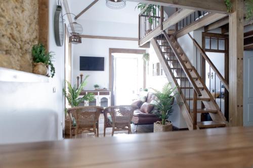 a living room with a staircase and a living room with a couch at Cafofos da Zeta in Setúbal