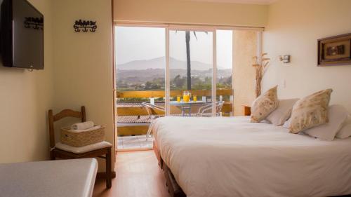 a bedroom with a bed and a large window at Riomar Apart Hotel in Concón