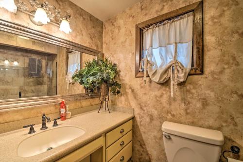 uma casa de banho com um lavatório, um WC e um espelho. em Central Ruidoso Mountain Home with Step-Free Access! em Ruidoso