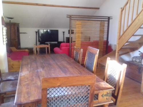 - une salle à manger avec une table et des chaises en bois dans l'établissement Appartement en loft 50m2 dans maison avec chambre en mezzanine et canapes lits dans salon, à Saint-Pierre-de-Chartreuse