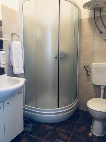 a bathroom with a shower and a toilet and a sink at Hotel Malta in Mostar