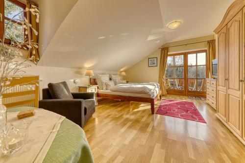 a living room with a bed and a couch at Haus Jägerfleck, Ihre Ferienwohnungen am Nationalpark Bayerischer Wald in Spiegelau