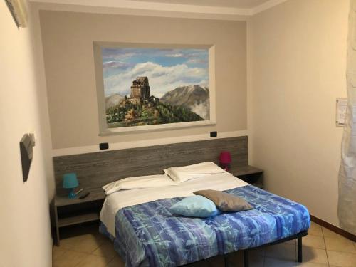 1 dormitorio con 1 cama con una pintura en la pared en Il Gatto e La Volpe, en Avigliana