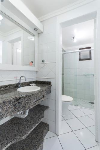 a bathroom with a sink and a toilet at Bombinhas Tourist Apart in Bombinhas