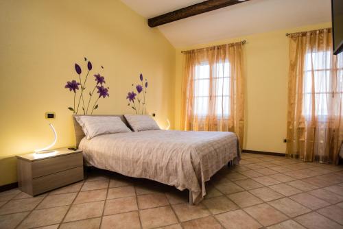 a bedroom with a bed with purple flowers on the wall at Villa-Alta in Imola