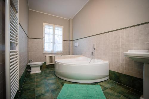 a bathroom with a tub and a sink and a toilet at Villa-Alta in Imola