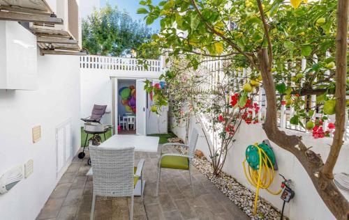 an outdoor patio with a tree and chairs at Chalet Can Parragó in Can Picafort