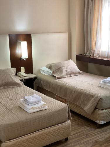 Habitación de hotel con 2 camas y toallas. en Charmoso Flat na Alameda Santos, en São Paulo