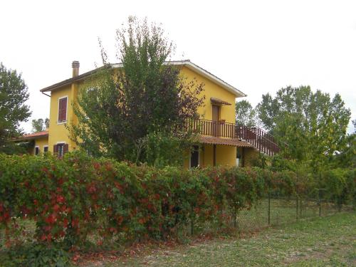 a yellow house with a balcony and some bushes at Etruria Life in Sutri